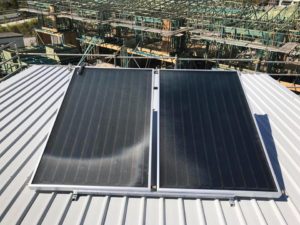 Solar hot water panels installed on a metal roof in Bribie Island, part of an energy-efficient hot water system